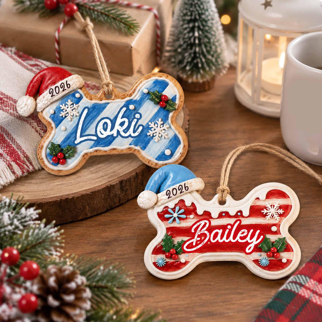 May include: Two bone-shaped Christmas ornaments with jute twine hangers. One ornament features blue stripes, the name Loki, a red Santa hat, and the year 2026. The other features red stripes, the name Bailey, a blue Santa hat, and the year 2026.