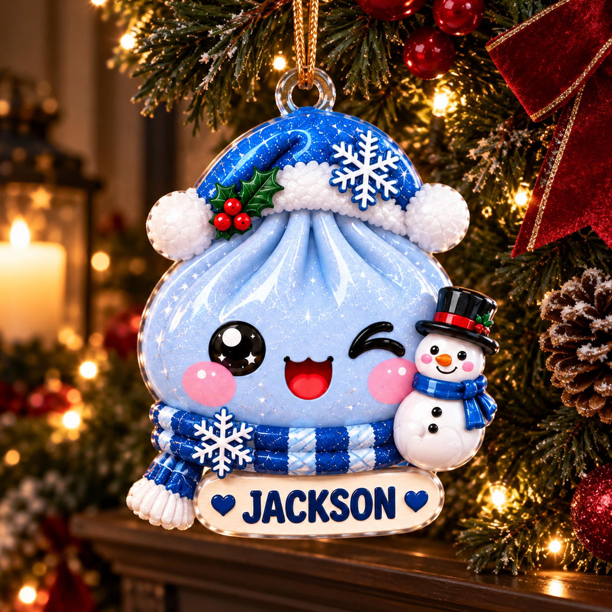 May include: A blue dumpling-shaped Christmas ornament with a glittery finish, wearing a blue Santa hat with a snowflake and a blue striped scarf. It features a winking face, a small snowman, and a white nameplate with the text JACKSON.