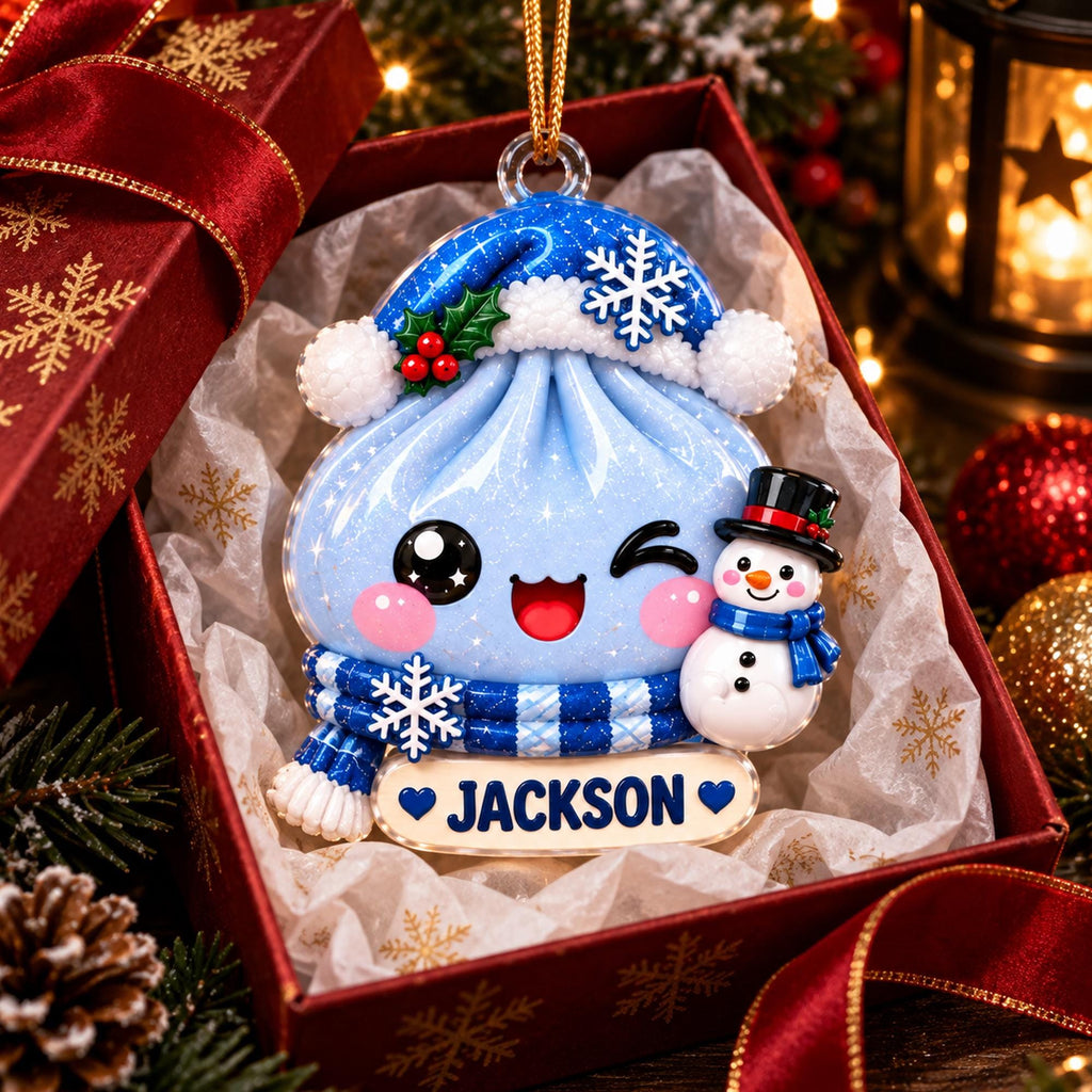 May include: A light blue dumpling-shaped Christmas ornament featuring a winking face, a blue Santa hat with a white snowflake, a blue plaid scarf, and a small snowman. A white name tag at the bottom displays the name JACKSON in blue capital letters.