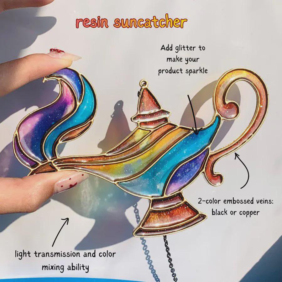May include: A resin suncatcher shaped like an oil lamp with a multi-colored gradient finish including blue, purple, yellow, and orange hues. The design features metallic outlines, glitter accents, and text labels describing light transmission and veins.