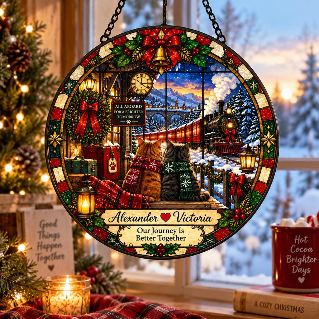 May include: A circular stained glass suncatcher featuring two cats wearing scarves sitting on a platform watching a steam train in a snowy landscape. The piece includes the text "ALL ABOARD FOR A BRIGHTER TOMORROW", "Alexander Victoria", and "Our Journey Is Better Together".