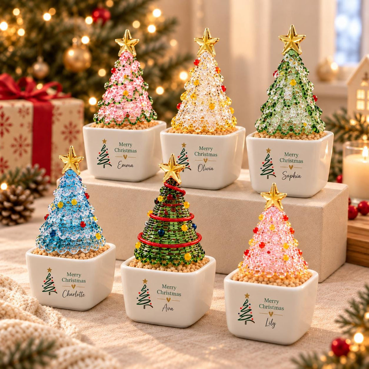 May include: Six miniature Christmas tree ornaments in white square ceramic pots. Each tree is crafted from colorful beads with a gold star topper. The pots feature the text Merry Christmas and a unique name: Emma, Olivia, Sophia, Charlotte, Ava, and Lily.