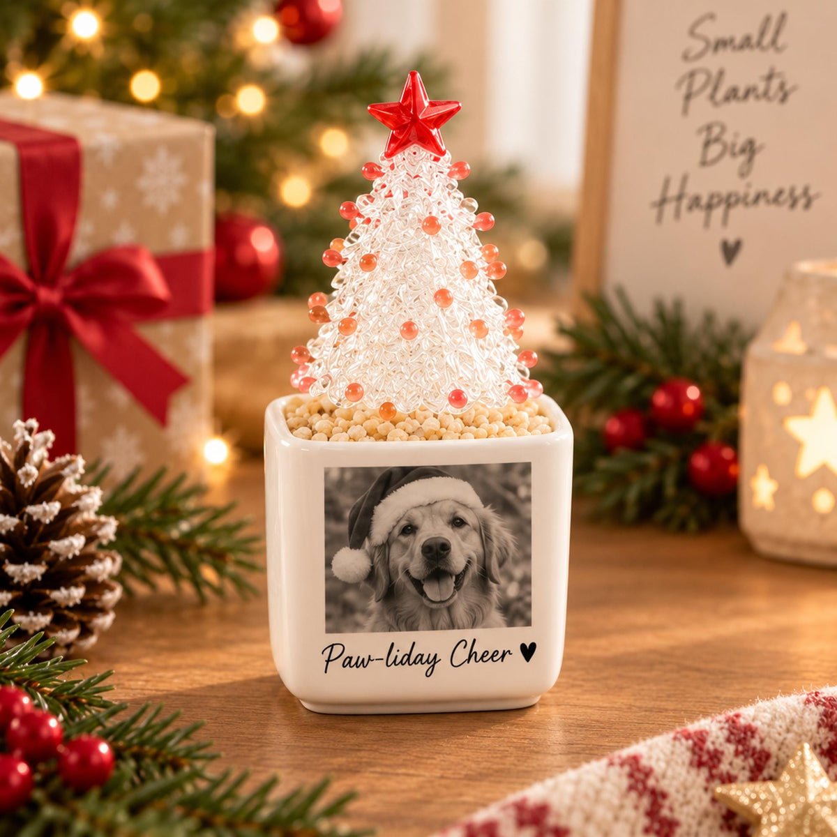 May include: A white square ceramic planter featuring a black and white photograph of a dog wearing a Santa hat, with the text Paw-liday Cheer and a heart icon. A clear beaded Christmas tree with a red star topper sits inside the planter.