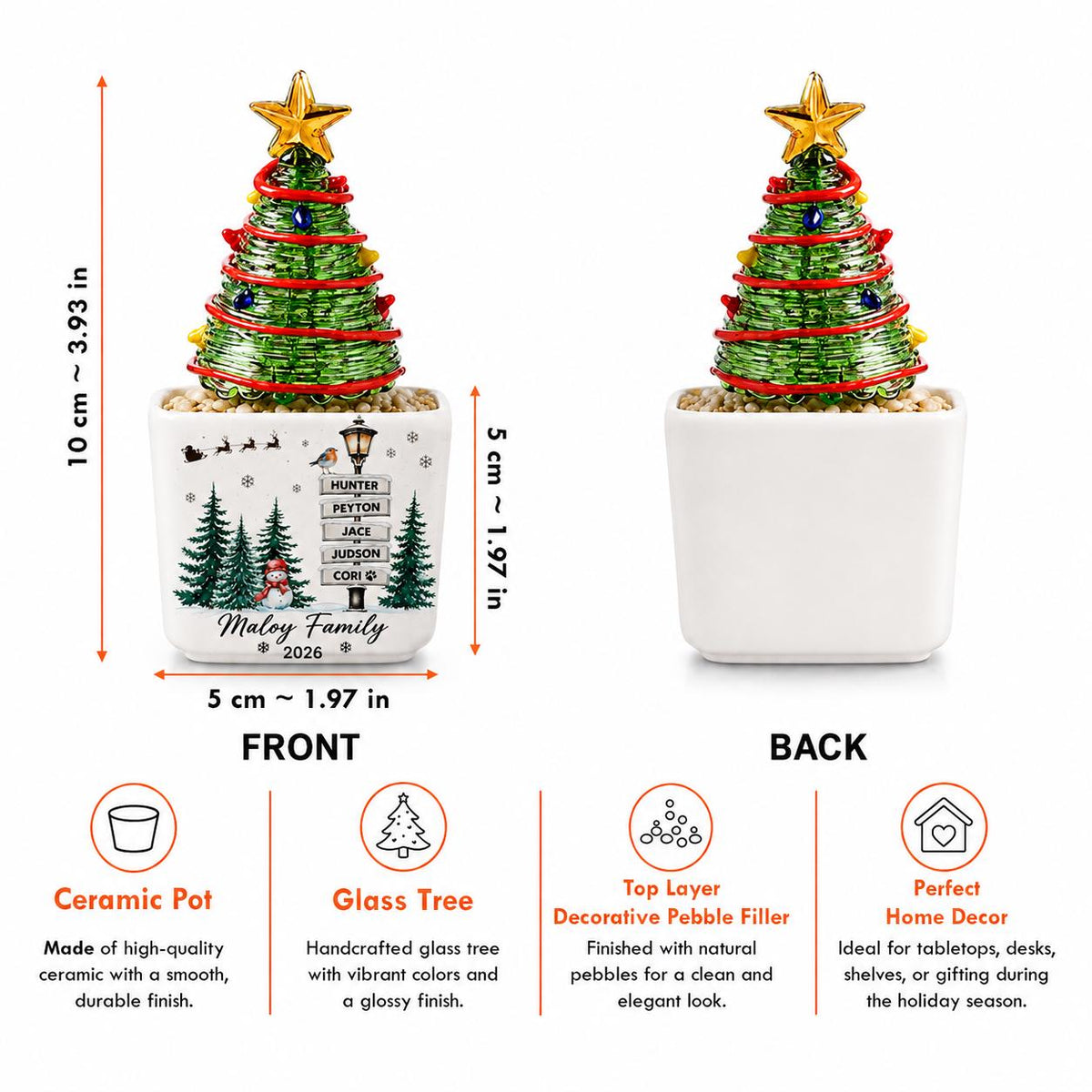 May include: A green glass Christmas tree with a gold star topper in a white ceramic pot. The pot features a printed winter scene with a signpost reading Hunter, Peyton, Jace, Judson, Cori, and Maloy Family 2026. Dimensions are 3.93 inches tall by 1.97 inches wide.