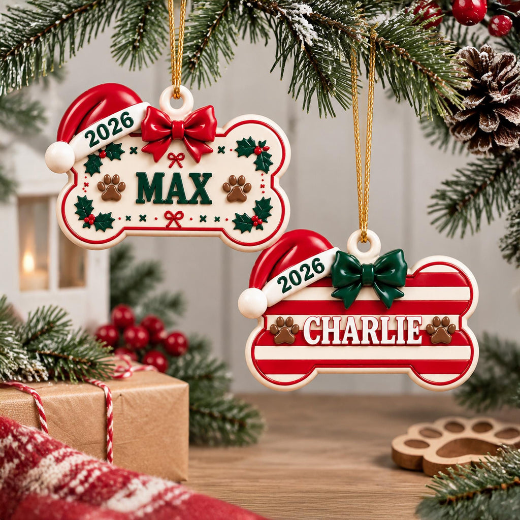 May include: Two bone-shaped Christmas ornaments hanging from a tree. One is cream with green holly, a red bow, and the name MAX. The other has red and white stripes, a green bow, and the name CHARLIE. Both feature a Santa hat and the year 2026.