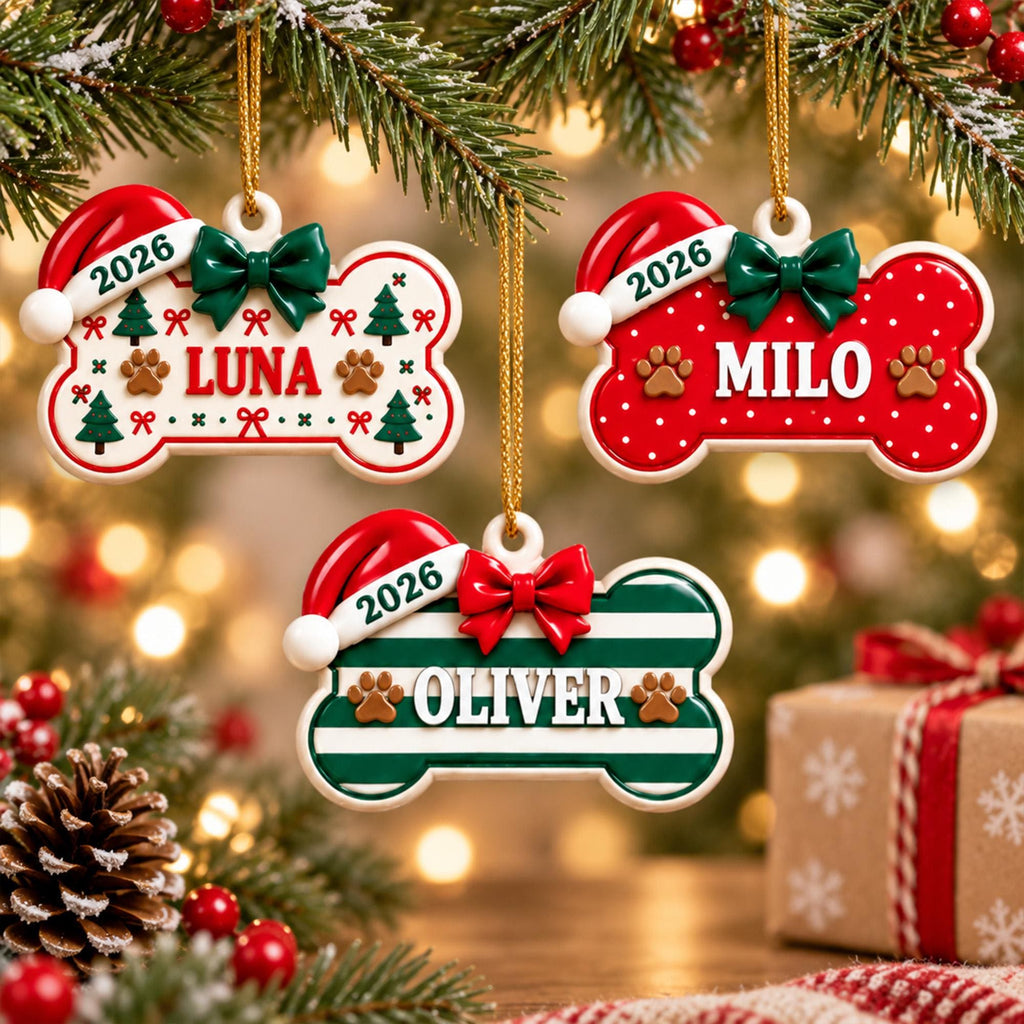 May include: Three bone-shaped Christmas ornaments hanging from gold strings. Each features a Santa hat with the year 2026, a bow, and a name: LUNA on a white background, MILO on a red background, and OLIVER on a green and white striped background.