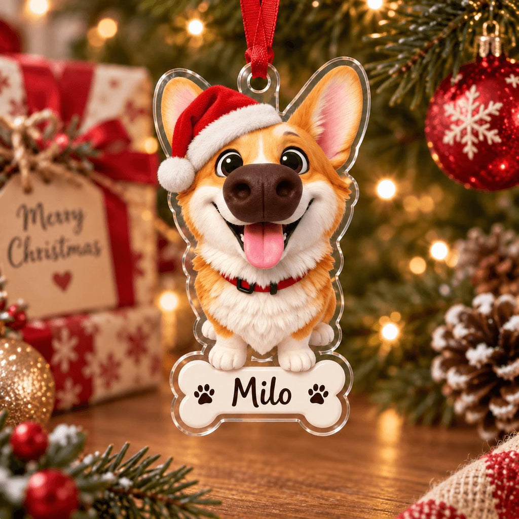 May include: A clear acrylic Christmas ornament shaped like a dog bone featuring a cartoon Corgi wearing a red and white Santa hat. The dog has a brown and white coat, a black collar, and its tongue is out. The name Milo is printed in black text.