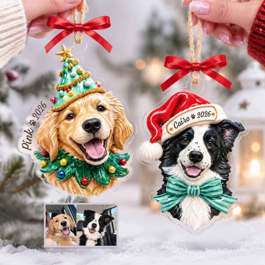 May include: Two custom acrylic Christmas ornaments featuring a golden retriever wearing a green tree hat and a black and white dog wearing a red Santa hat. Both ornaments have red ribbon bows, jute hanging strings, and the text Pink 2026 and Cairo 2026.