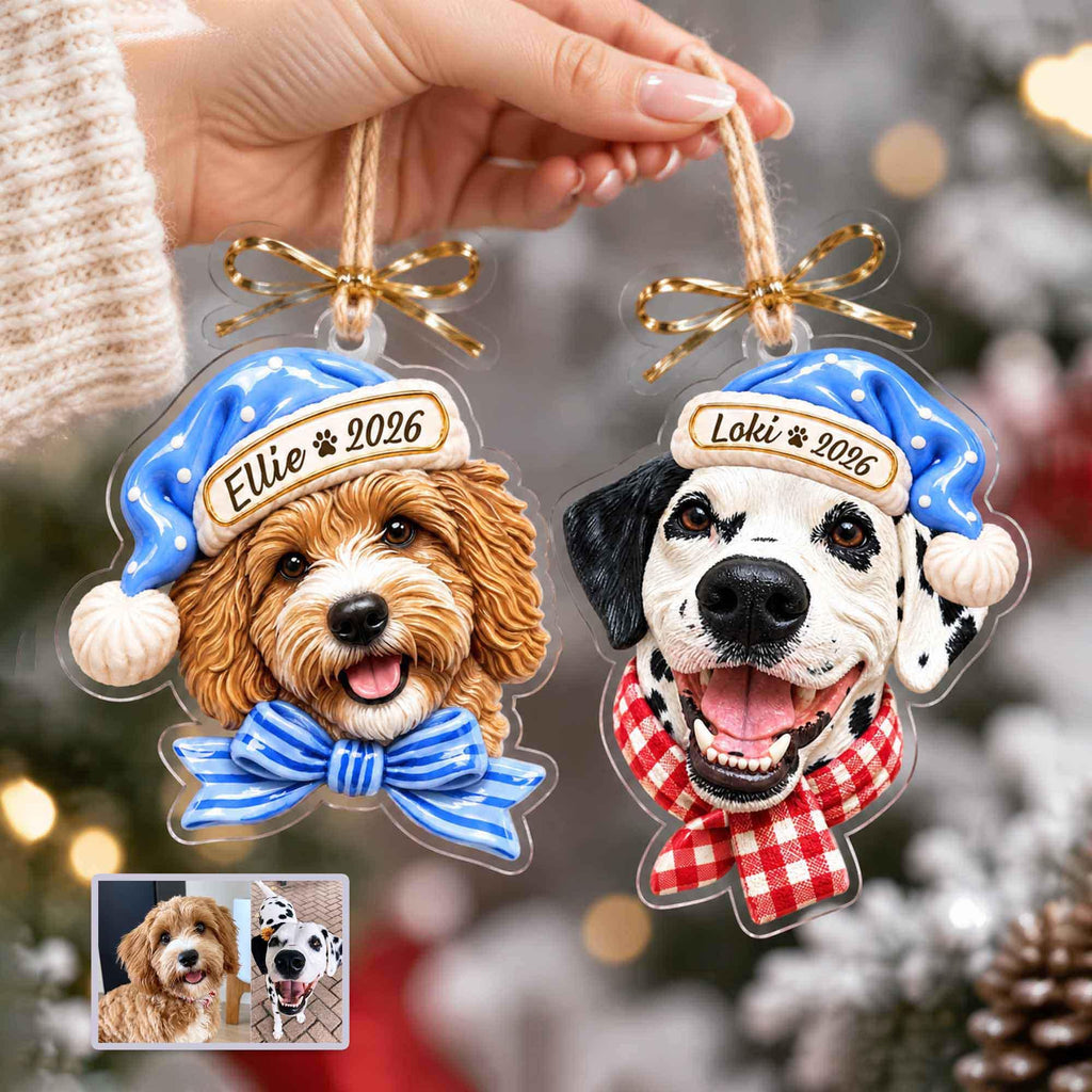 May include: Two custom acrylic ornaments featuring dog portraits. One shows a golden-brown dog with a blue bow and blue hat labeled 'Ellie 2026'. The other shows a black and white spotted dog with a red and white checkered scarf and blue hat labeled 'Loki 2026'.