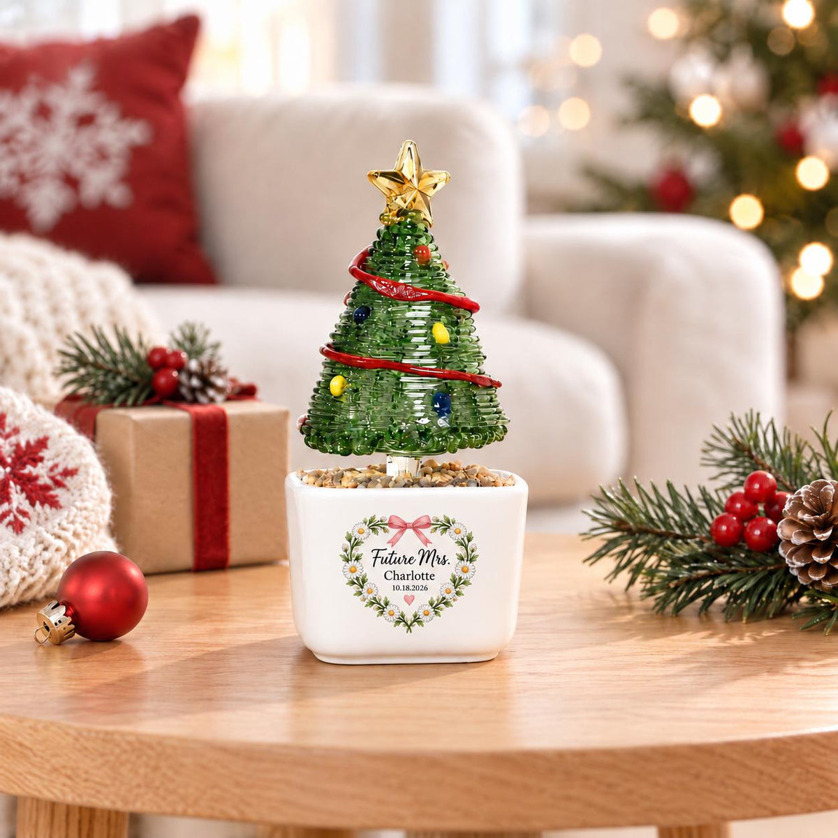May include: A green glass Christmas tree figurine with a gold star topper, red garland, and colorful ornaments, set in a white square planter. The planter features a floral heart graphic with the text Future Mrs. Charlotte 10.18.2026.