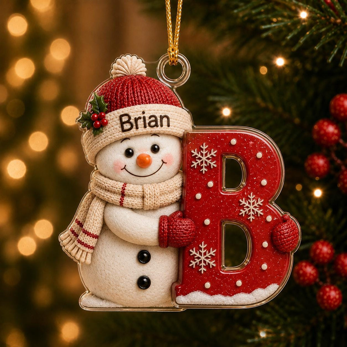 May include: A Christmas ornament featuring a white snowman wearing a red knit hat with the name Brian printed on the brim and a beige scarf. The snowman holds a large, glittery red letter B decorated with white snowflakes and a gold string.