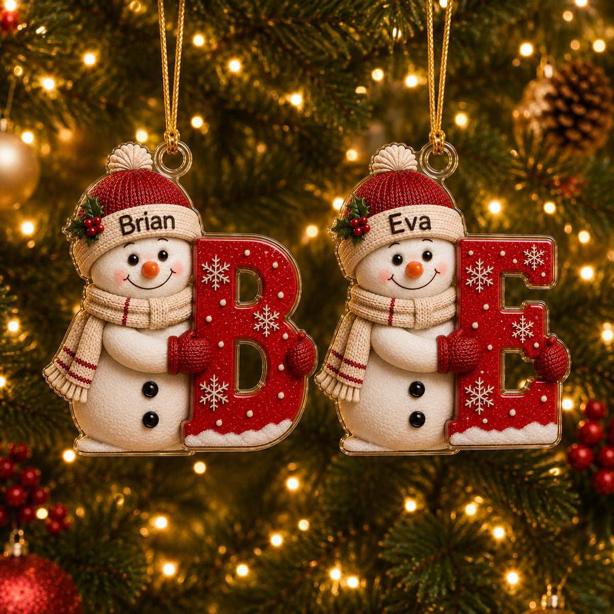 May include: Two hanging Christmas ornaments featuring smiling snowmen wearing red knit hats and scarves. One snowman holds a large red letter B with white snowflakes and the name Brian, the other holds a red letter E with the name Eva.