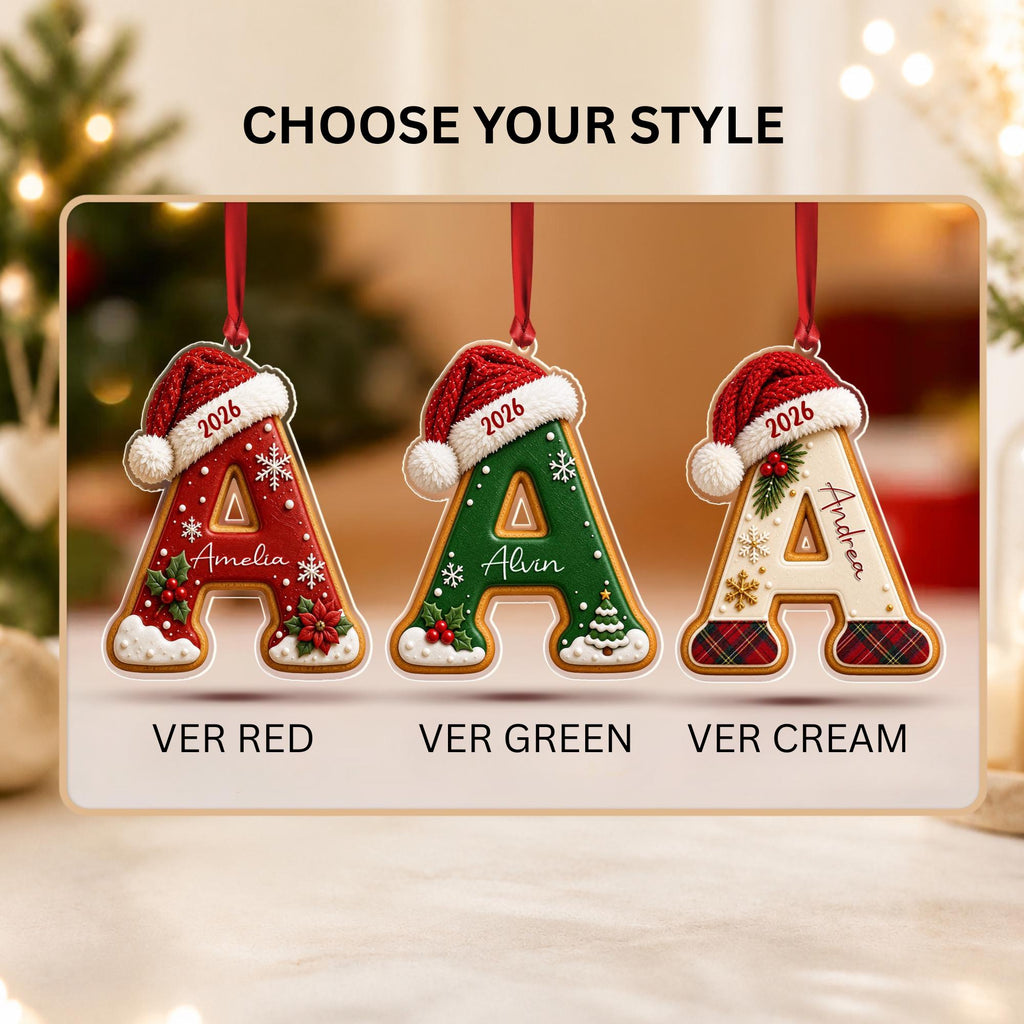 May include: Three letter A-shaped Christmas ornaments hanging by red ribbons. Each features a red Santa hat, the year 2026, and festive details. The red version says Amelia, the green says Alvin, and the cream says Andrea. Text reads CHOOSE YOUR STYLE.