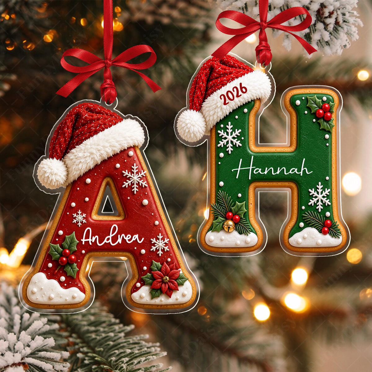 May include: Two letter-shaped Christmas ornaments hanging by red ribbons. The letter A is red with white snowflakes, a poinsettia, and the name Andrea. The letter H is green with white snowflakes, holly, and the name Hannah. Both wear Santa hats.