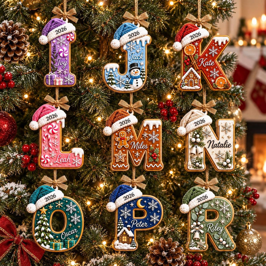 May include: Nine hanging Christmas ornaments shaped as letters I, J, K, L, M, N, O, P, and R. Each letter features a unique holiday theme, a knit hat with the year 2026, and a personalized name. The ornaments are suspended by small brown bows.