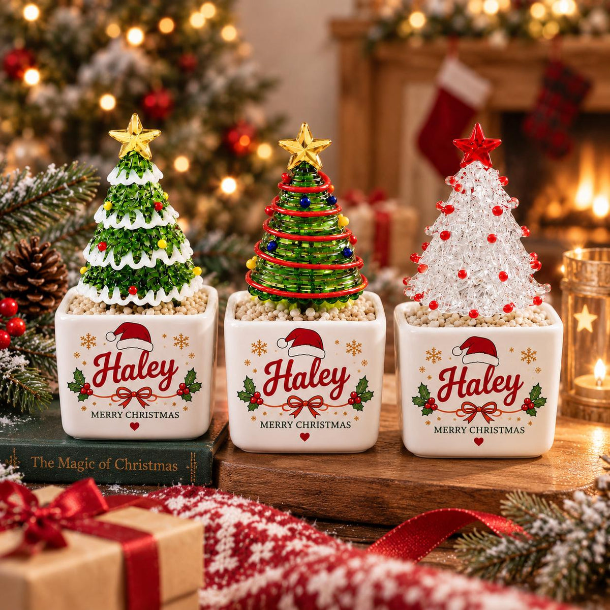 May include: Three decorative Christmas tree ornaments in square white ceramic pots. Each pot features the name Haley, a Santa hat, holly, and the text Merry Christmas. The trees are green with white tips, green with red garland, and clear with red beads.
