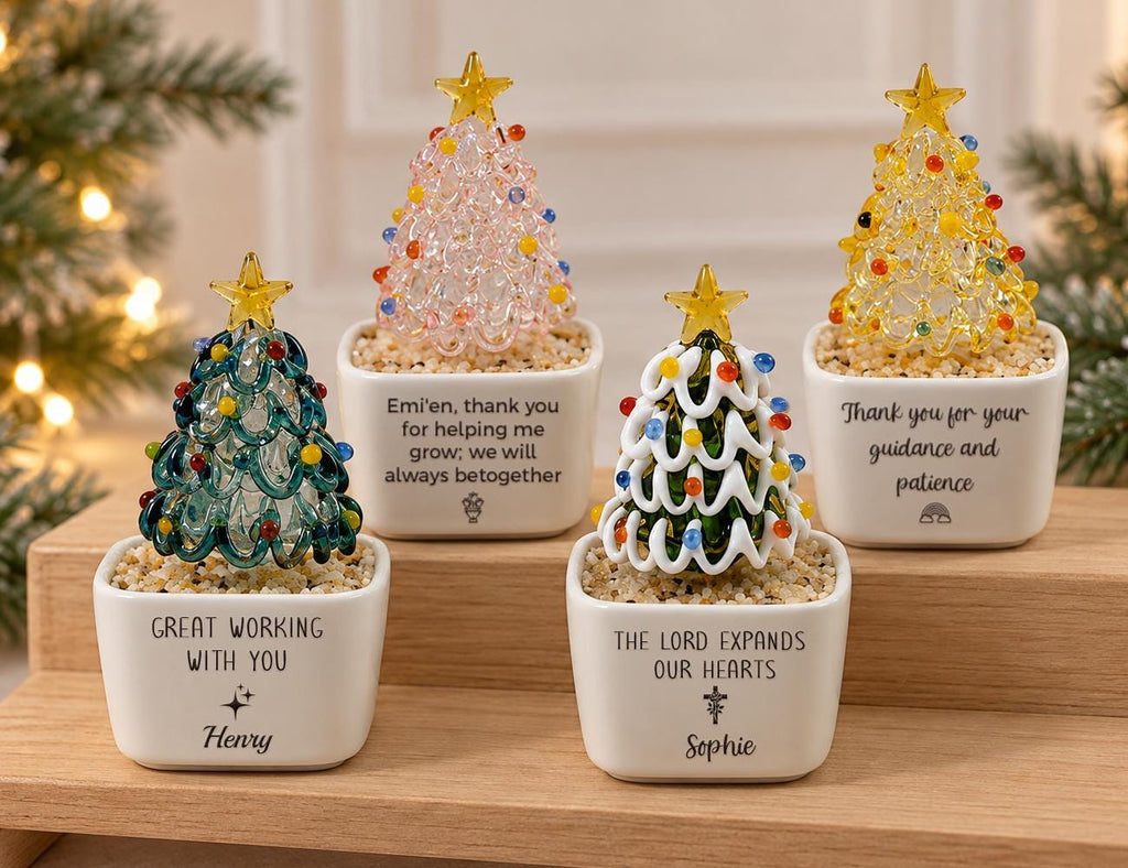 May include: Four glass Christmas tree ornaments in white square ceramic pots filled with small pebbles. Each tree features a yellow star topper and colorful glass beads. The pots are printed with personalized messages and names including Henry and Sophie.