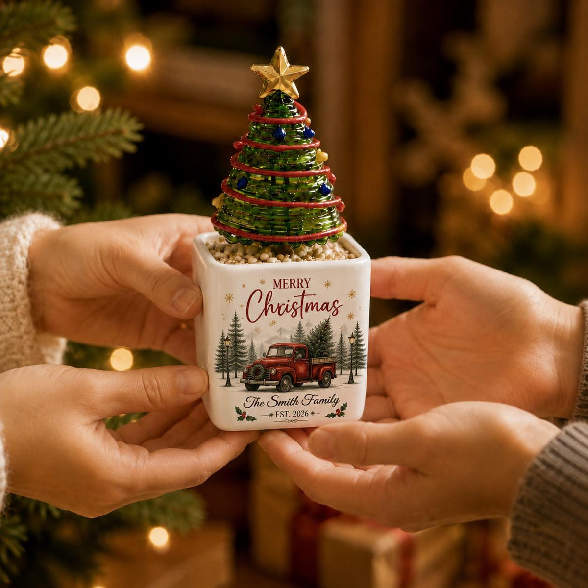 May include: A white ceramic square planter featuring a green wire Christmas tree with a gold star topper. The planter displays a red truck graphic, the text Merry Christmas, and the custom text The Smith Family EST. 2026 in black script.