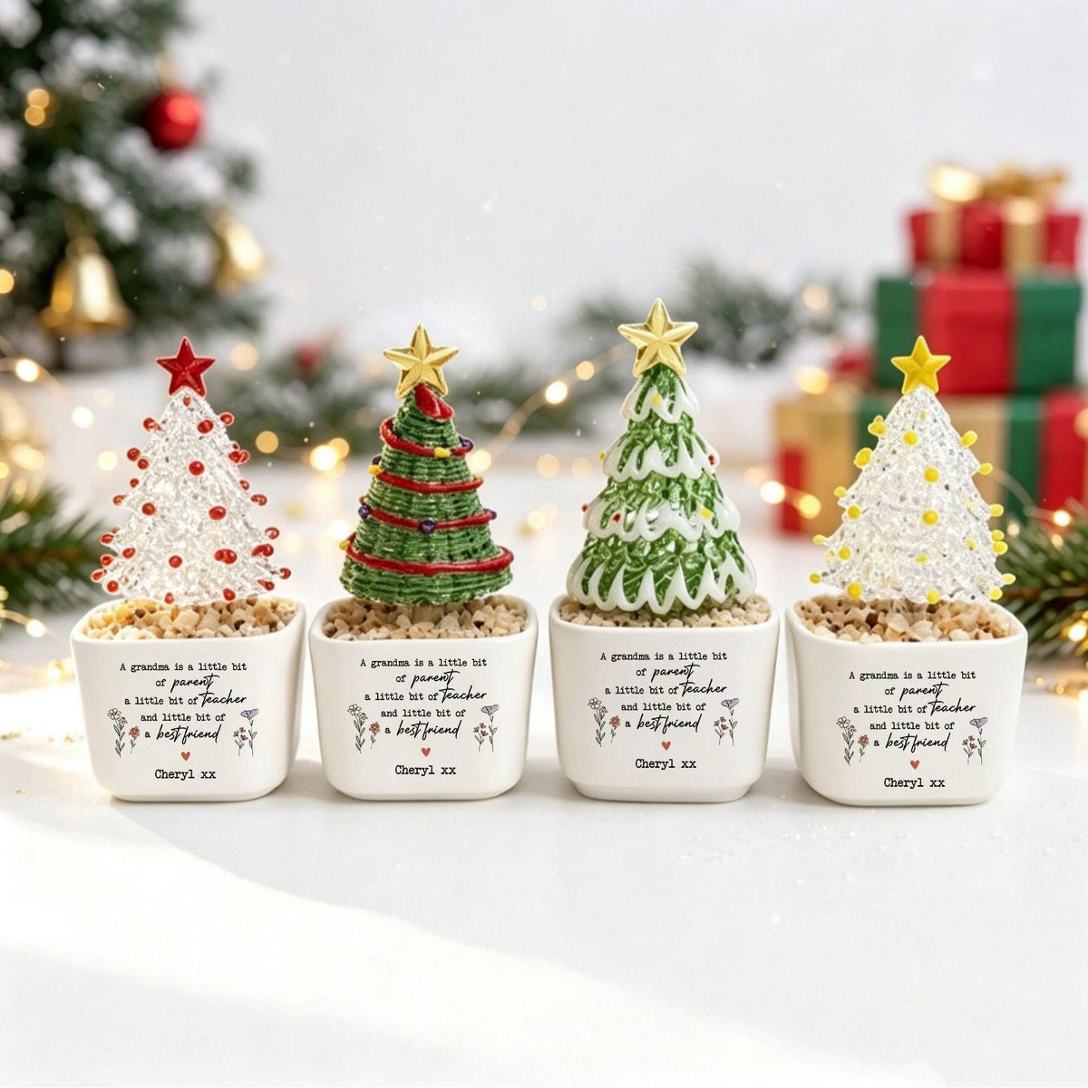 May include: Four small decorative Christmas trees in white square ceramic pots. Each pot features the text: A grandma is a little bit of parent a little bit of teacher and little bit of a best friend, with the name Cheryl xx printed at the bottom.