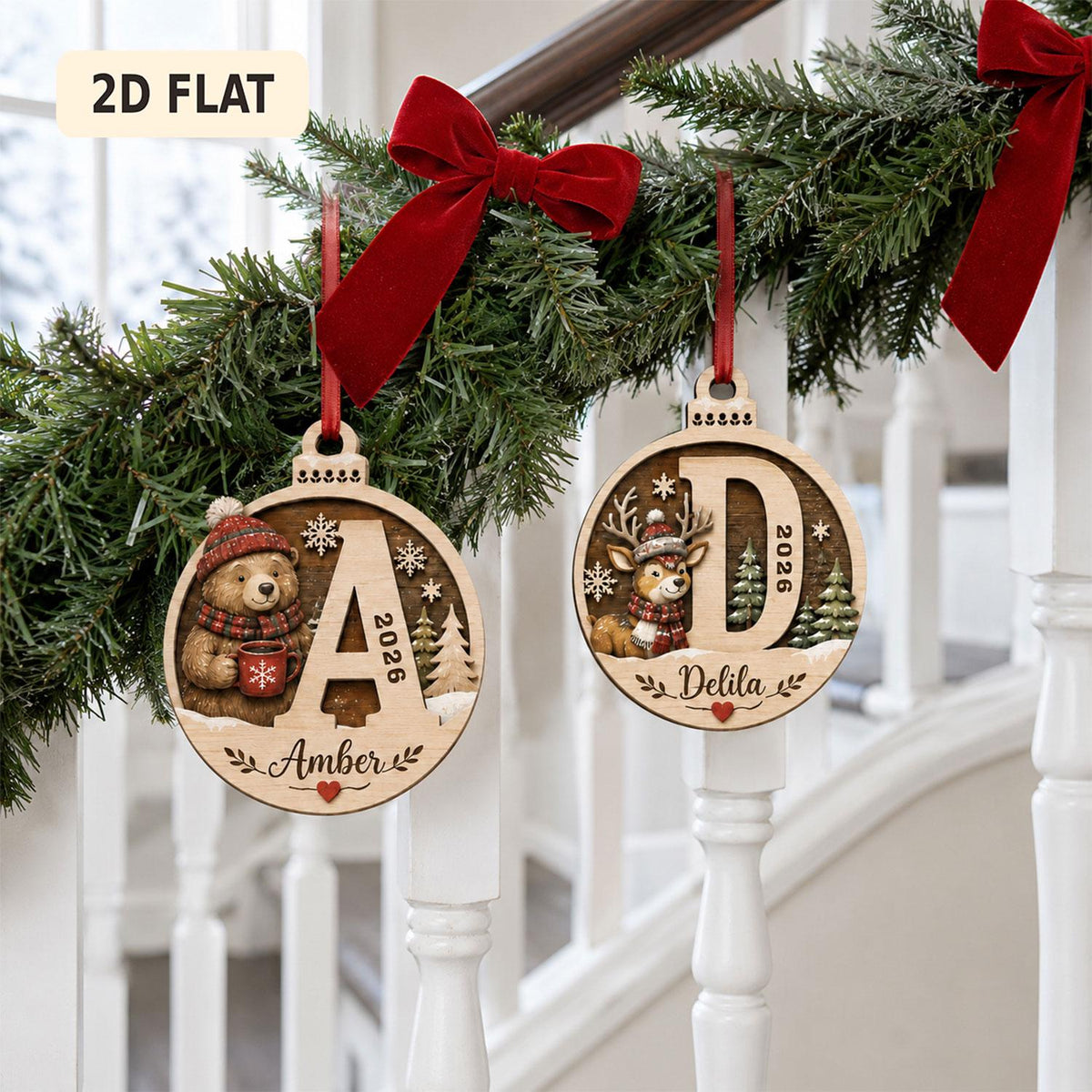 May include: Two round wooden Christmas ornaments hanging from red ribbons. The left ornament features a bear, the letter A, the year 2026, and the name Amber. The right ornament features a deer, the letter D, the year 2026, and the name Delila.