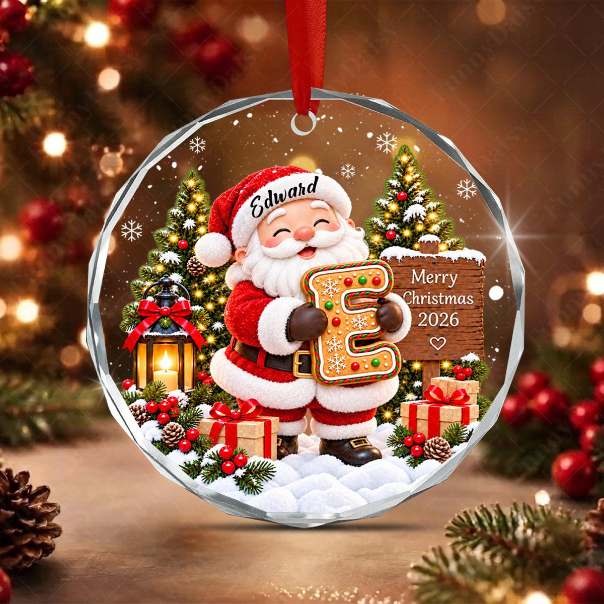 May include: A round, faceted glass Christmas ornament featuring a cartoon Santa Claus holding a large gingerbread letter E. The ornament displays the name Edward on Santa's hat, a wooden sign reading Merry Christmas 2026, pine trees, and gifts.