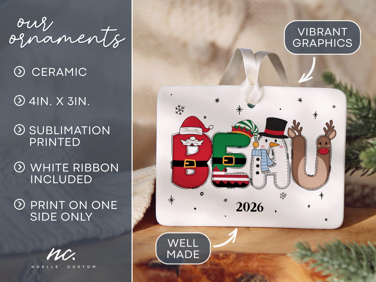 May include: A rectangular white ceramic ornament measuring 4 inches by 3 inches, featuring the name BEAU spelled out in festive holiday characters including Santa, an elf, a snowman, and a reindeer, with the year 2026 and a white ribbon.
