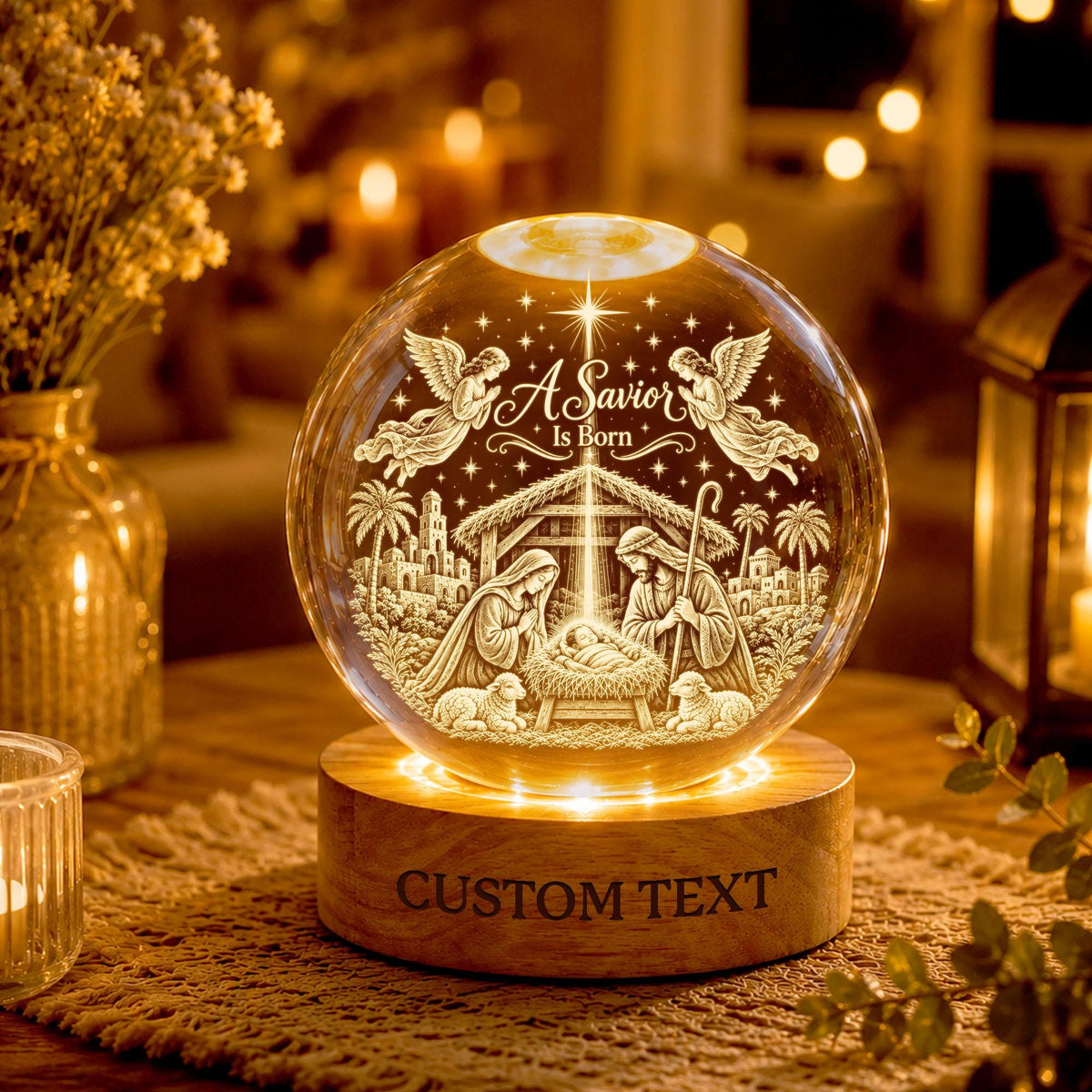 May include: A clear glass sphere featuring an etched nativity scene with the text A Savior Is Born, two angels, and a manger. The sphere rests on a circular wooden base with the engraved text CUSTOM TEXT, illuminated from below by warm light.