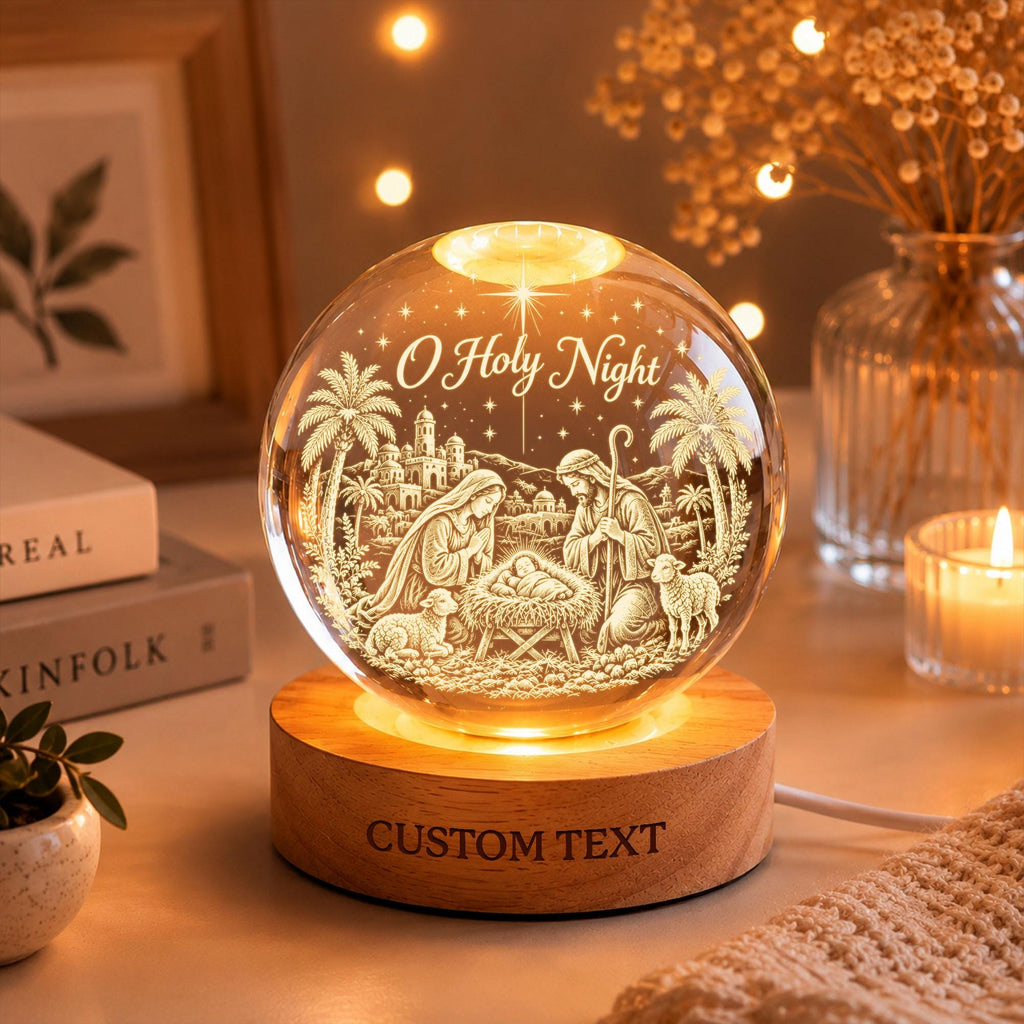 May include: A spherical glass night light featuring a laser-engraved nativity scene with the text O Holy Night. The glass orb rests on a circular wooden base with the words CUSTOM TEXT engraved on the front, illuminated from within by a warm light.
