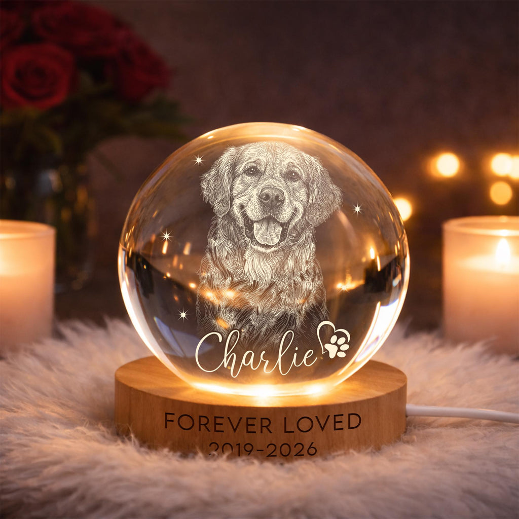 May include: A clear glass sphere with an engraved image of a Golden Retriever dog, lit from below. The sphere sits on a wooden base with the words "FOREVER LOVED 2019-2026" and the name "Charlie".