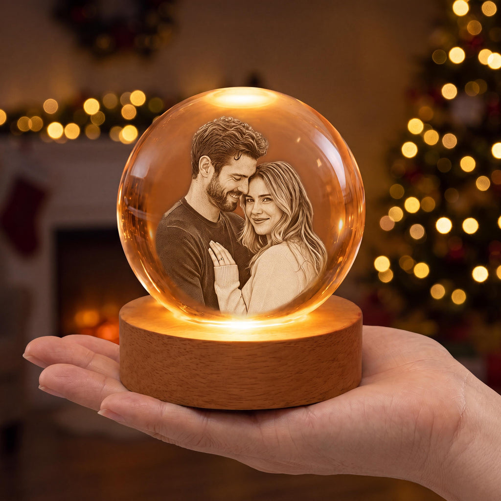 May include: A clear glass sphere containing a laser-etched monochrome portrait of a couple, mounted on a circular light-colored wooden base that illuminates the interior. The sphere displays a detailed image of a person with a beard and a person with long hair.