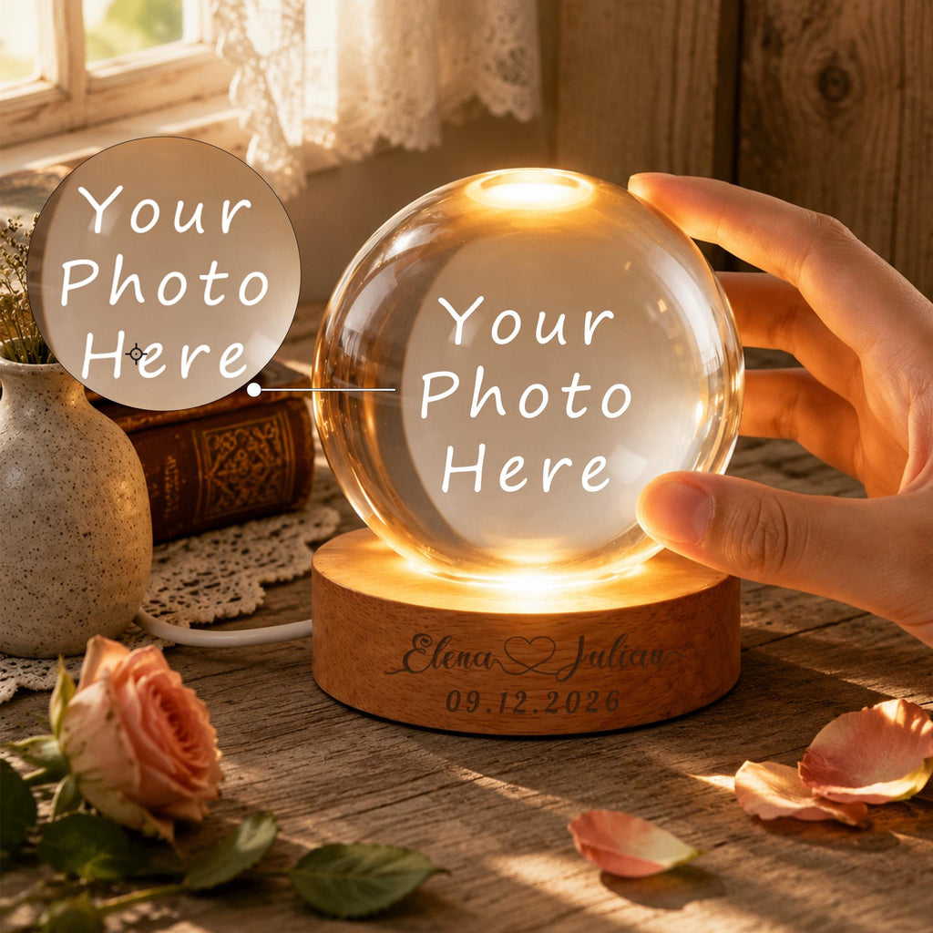 May include: A clear glass sphere lamp resting on a circular wooden base. The base is engraved with the text Elena & Julian and the date 09.12.2026. The sphere features a glowing light and the placeholder text Your Photo Here in white lettering.