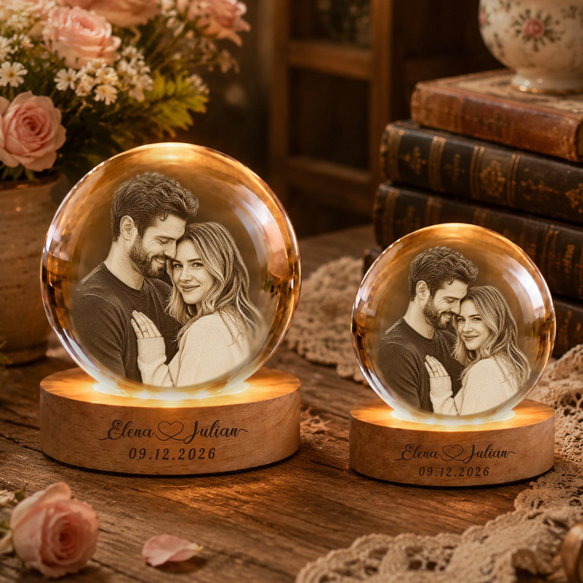 May include: Two spherical glass ornaments featuring laser-etched portraits of a couple. Each globe sits on a circular wooden base engraved with the names Elena and Julian and the date 09.12.2026. The bases are illuminated from within.