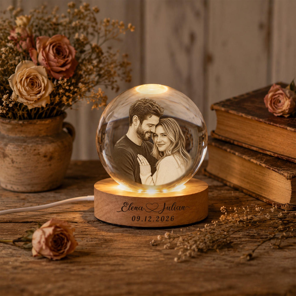 May include: A spherical glass orb featuring a laser-etched portrait of a couple, illuminated by a circular wooden base. The base is engraved with the text Elena Julian and the date 09.12.2026, connected by a white power cord to the light source.