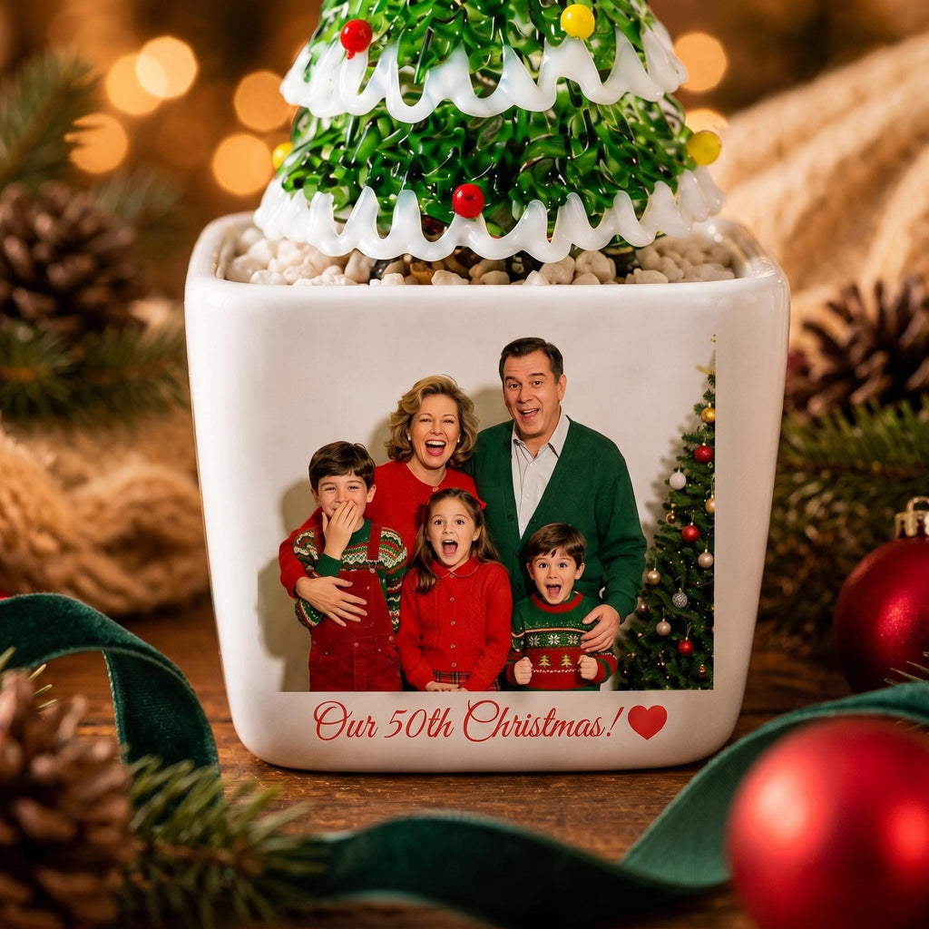 May include: A white square ceramic planter featuring a printed photograph of a family of four posing in front of a Christmas tree. The text "Our 50th Christmas!" with a red heart is printed below the photo. A green glass tree sits inside.