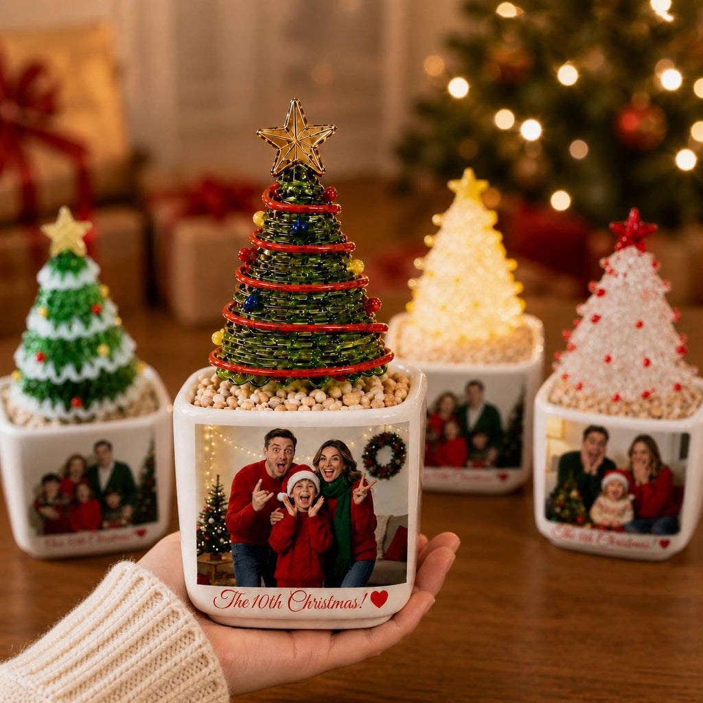 May include: A square white ceramic planter featuring a custom photo of a family and the text The 10th Christmas! with a red heart. The planter holds a decorative green wire Christmas tree topped with a gold star and filled with small tan beads.