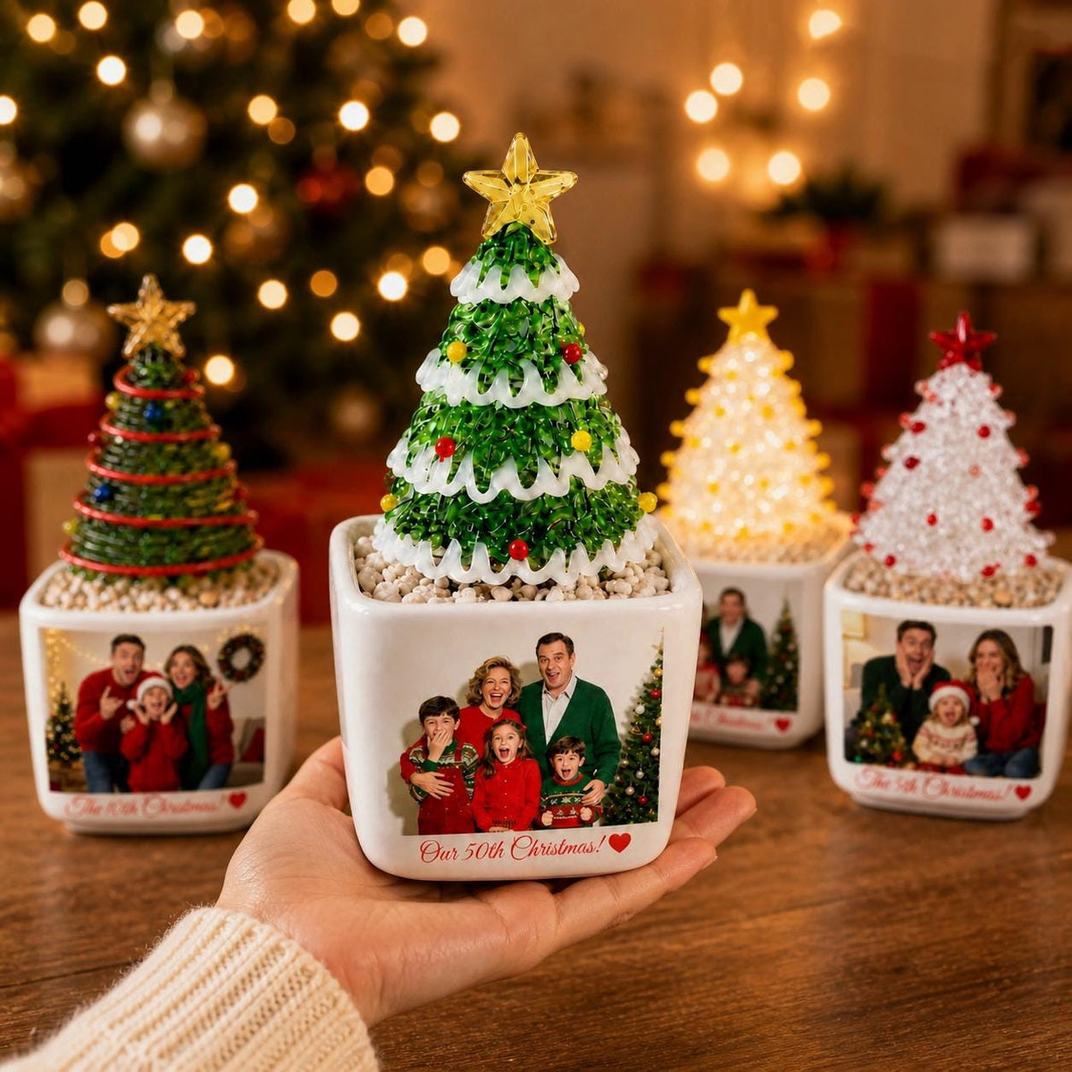 May include: Four decorative tabletop Christmas trees in square white ceramic planters. Each tree features a unique design with colorful beads and a star topper. The planters display custom family photographs and the text Our 50th Christmas! with a heart.