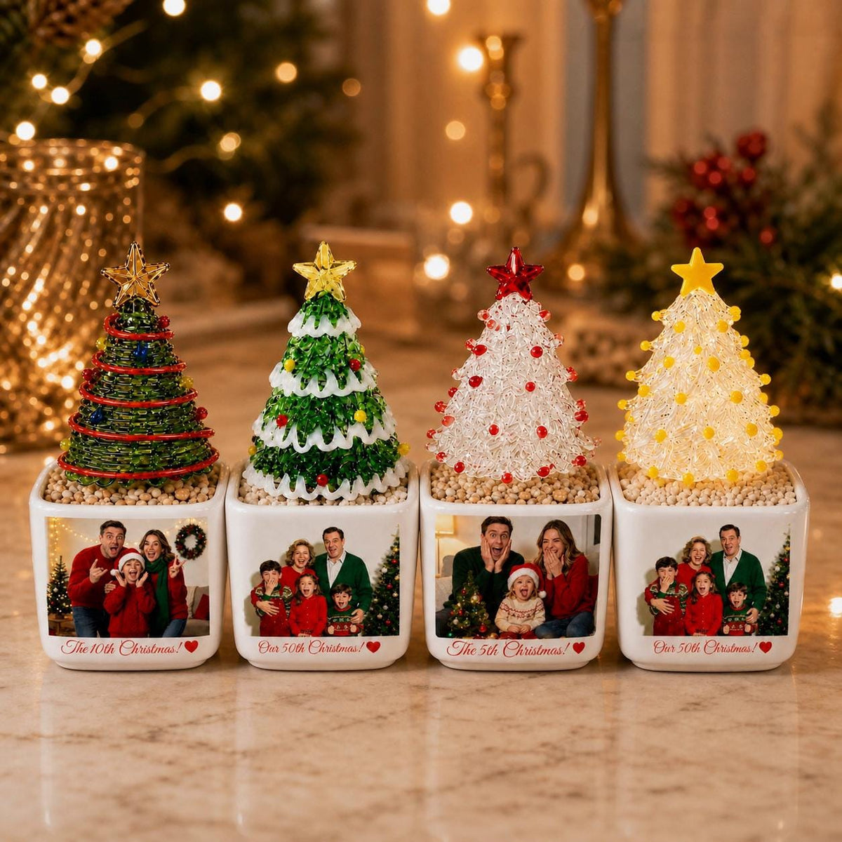 May include: Four square white ceramic planters, each topped with a decorative wire-wrapped Christmas tree. The planters feature printed family photographs and text reading The 10th Christmas or The 50th Christmas with a small red heart icon.