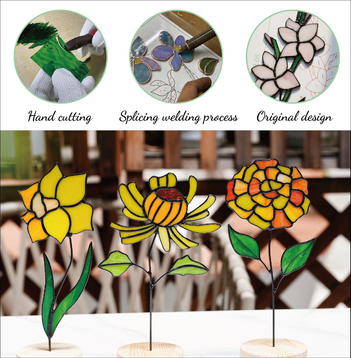 May include: Three stained glass flower sculptures in yellow, orange, and red hues, each with a black stem and green leaves. The flowers are mounted on wooden bases. The image also shows the hand cutting, splicing welding process, and original design.