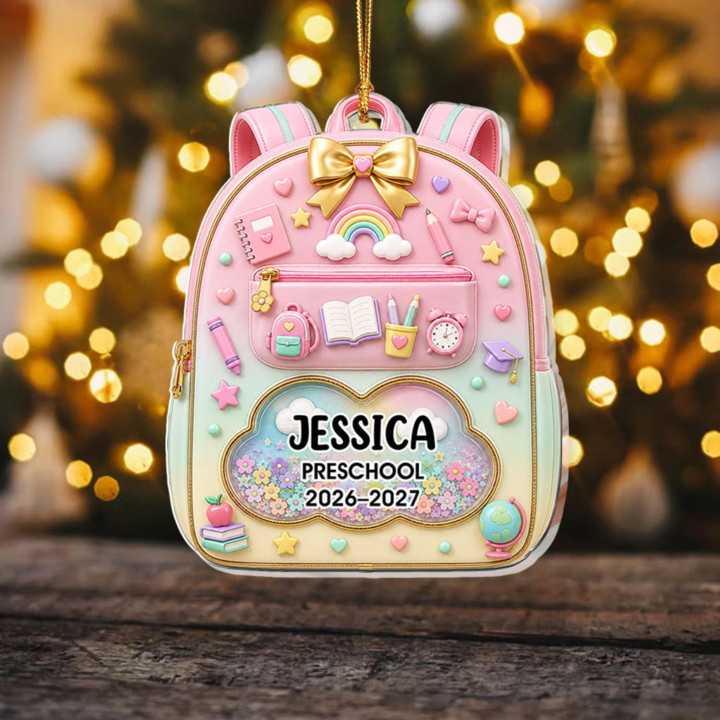 May include: A pastel-colored backpack ornament featuring a gold bow, a rainbow, and school-themed icons. The center cloud-shaped window displays the text JESSICA, PRESCHOOL, and 2026-2027, surrounded by colorful floral accents and a gold hanging cord.