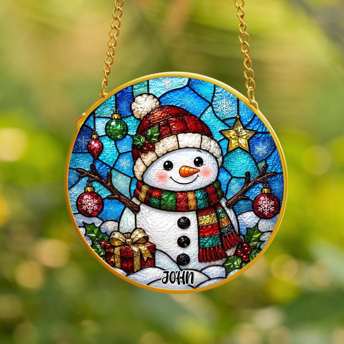 May include: A round stained glass suncatcher featuring a snowman wearing a red hat and a multi-colored scarf. The background is a blue mosaic pattern with hanging ornaments, a gold star, and holly. The name JOHN is printed at the bottom.