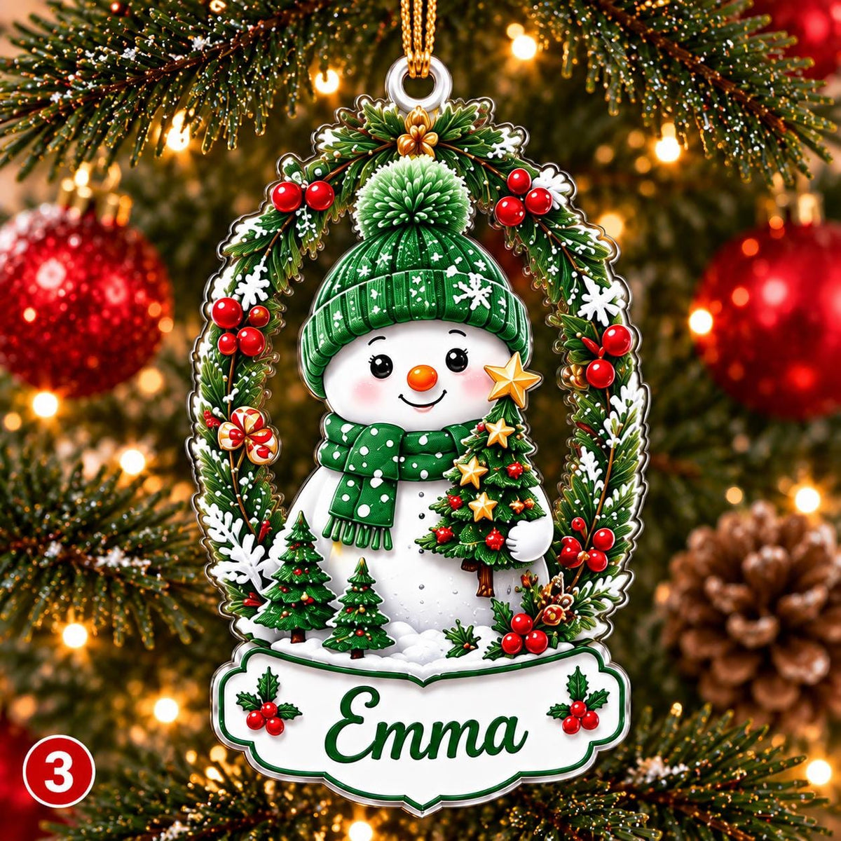 May include: A Christmas ornament featuring a white snowman wearing a green knit hat and scarf, holding a small decorated tree. The snowman is framed by a wreath of pine branches, red berries, and white snowflakes, with a nameplate reading Emma.