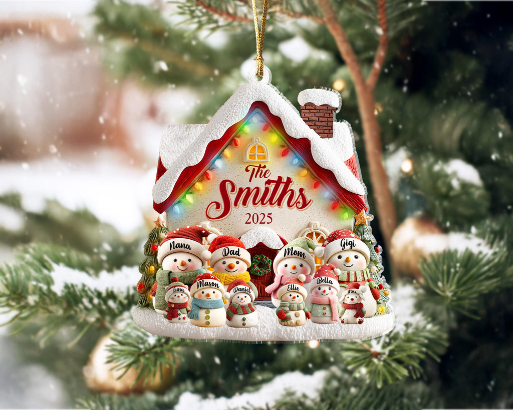 May include: A personalized Christmas ornament shaped like a snow-covered house, featuring a family of snowmen. The ornament has the family name "The Smiths" and the year "2025" displayed. The house is decorated with colorful lights and snow.