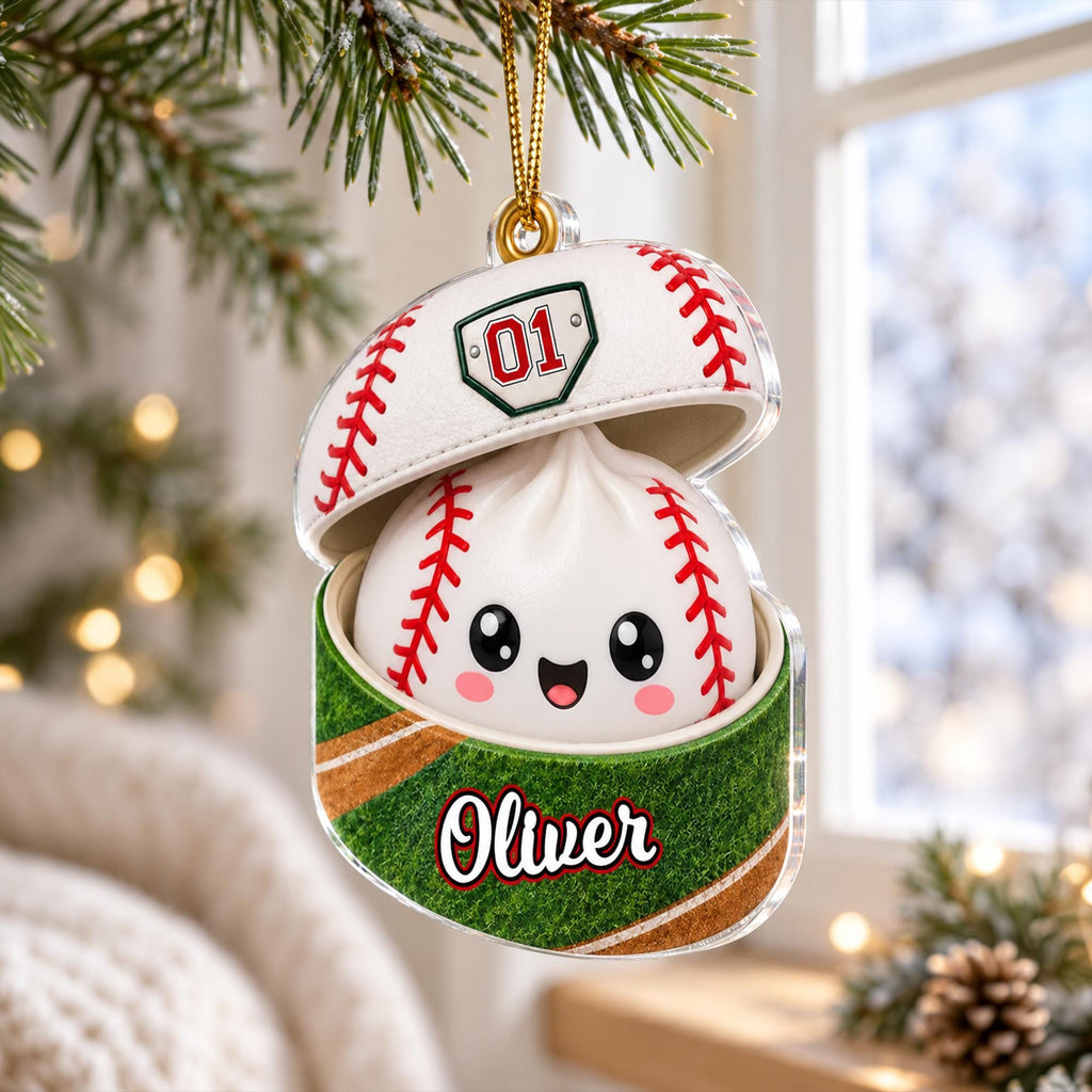 A personalized baseball ornament with a smiling face and the name "Olivier" on it, hanging from a tree branch.