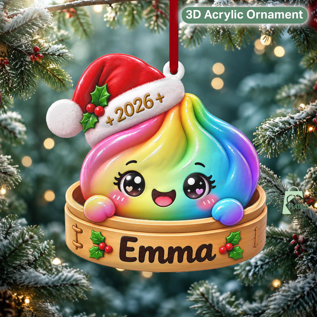 May include: A 3D acrylic ornament featuring a rainbow-colored dumpling character wearing a red Santa hat with the text 2026. The dumpling sits in a wooden bamboo steamer basket labeled with the name Emma and decorated with holly berries.