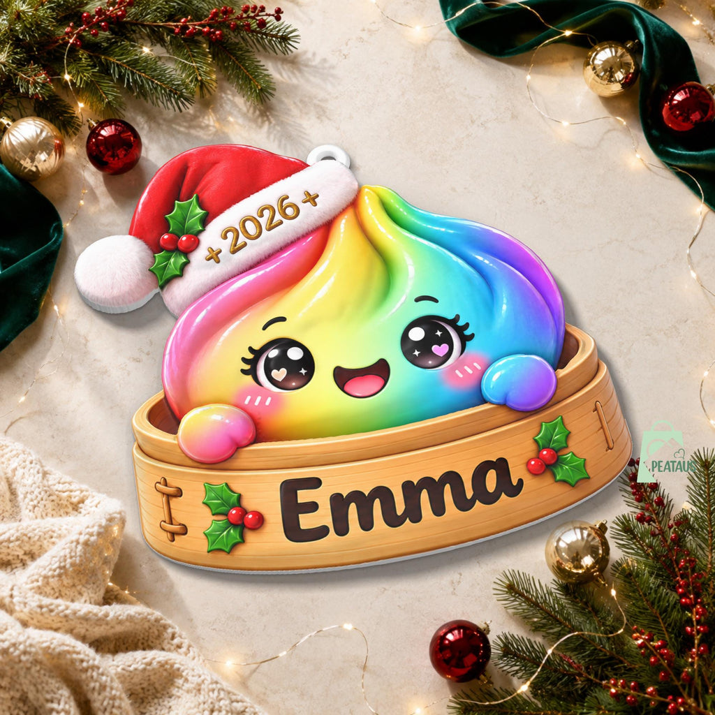 May include: A rainbow-colored dumpling character with a smiling face and large eyes, wearing a red and white Santa hat with the text 2026. The dumpling sits inside a wooden steamer basket featuring the name Emma and green holly leaf accents.