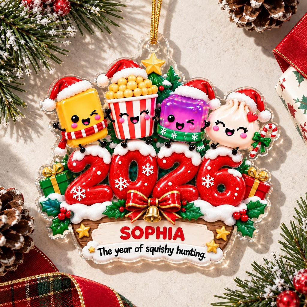 May include: A Christmas ornament featuring four cartoon characters wearing Santa hats above the red glittery numbers 2026. The base includes a banner with the name SOPHIA and the text The year of squishy hunting, surrounded by green holly and gifts.