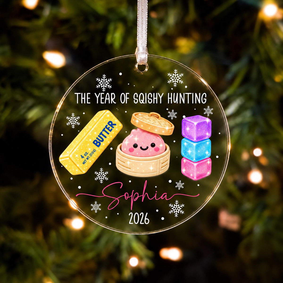 A clear ornament with a cartoon image of a child's face, surrounded by various holiday-themed objects such as a snowflake, a snowman, and a snowman.