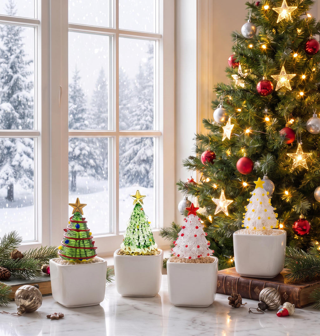 May include: Four miniature decorative Christmas trees in white square ceramic pots. Each tree features a unique glass design with colorful accents and a star topper, displayed on a surface with pine branches and vintage ornaments.