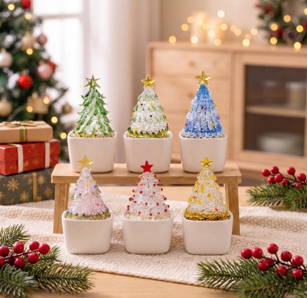 May include: Six miniature glass Christmas trees in white square ceramic pots, arranged on a wooden stand. The trees feature various colors including green, blue, pink, red, and yellow, each topped with a small gold or red star ornament.