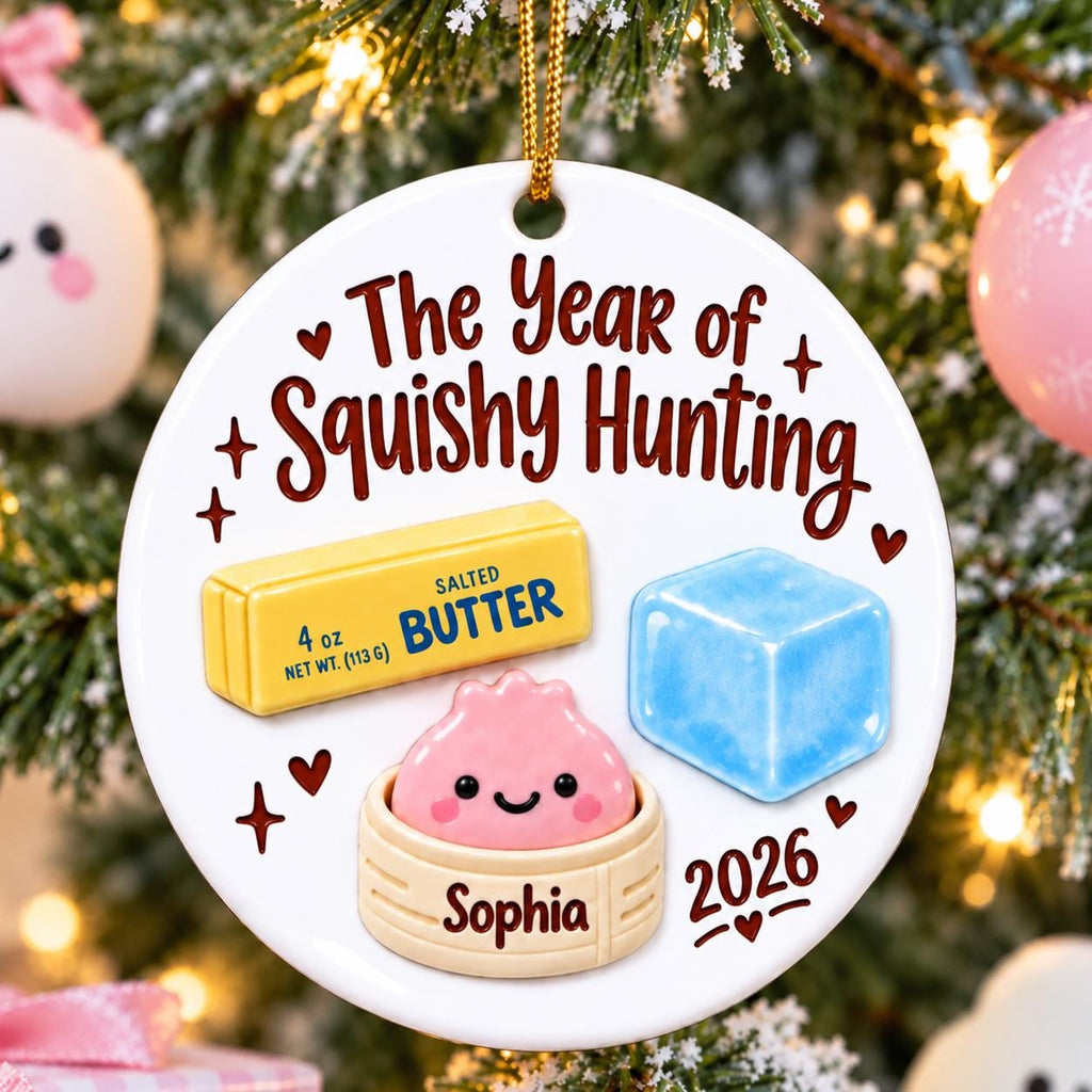 May include: A round white ceramic ornament featuring the text The Year of Squishy Hunting, a yellow stick of 4 oz salted butter, a blue ice cube, and a pink smiling dumpling in a steamer basket with the name Sophia and the year 2026 printed.